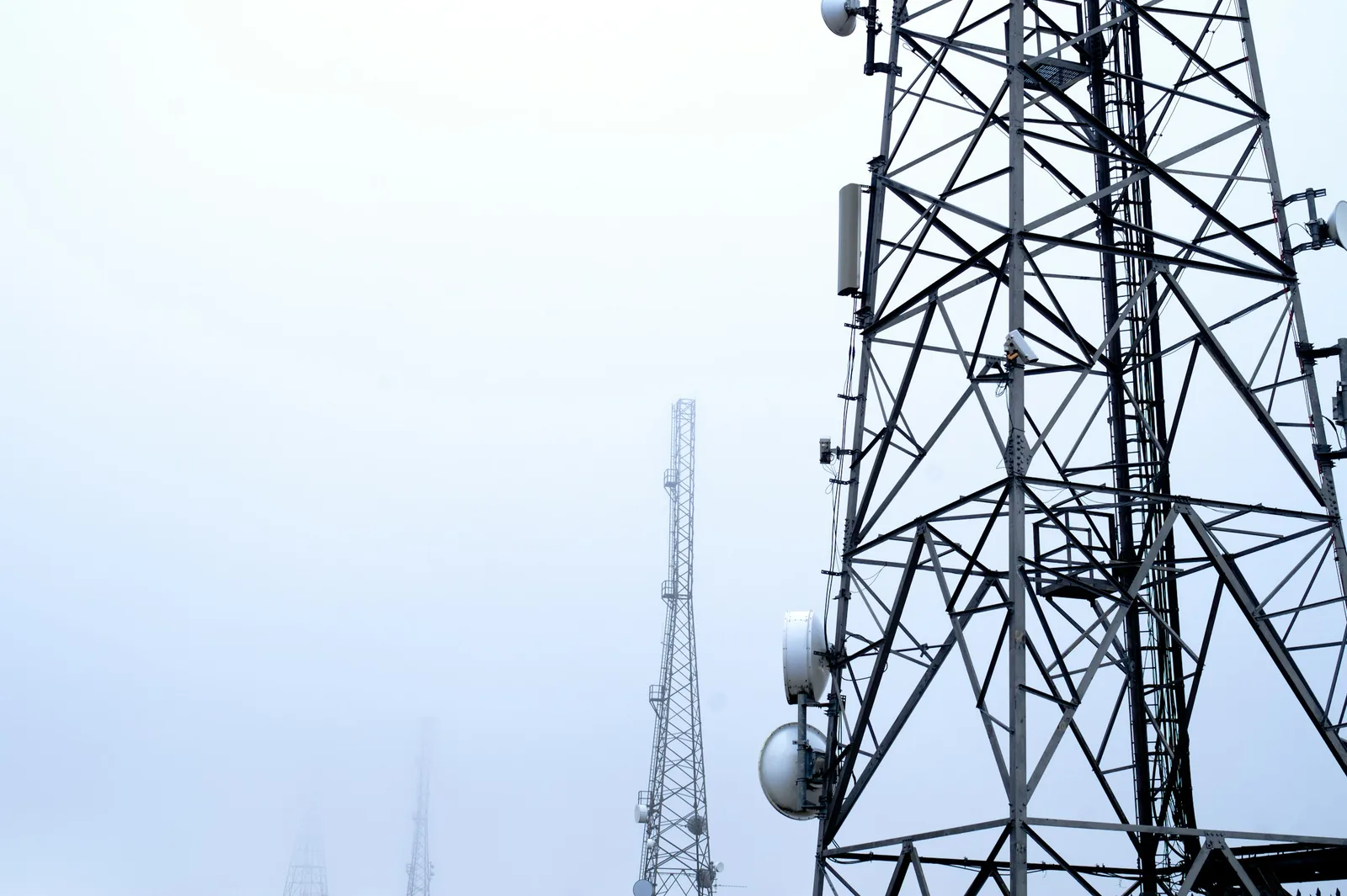 A lattice tower carrying cellular antennas, seen from below