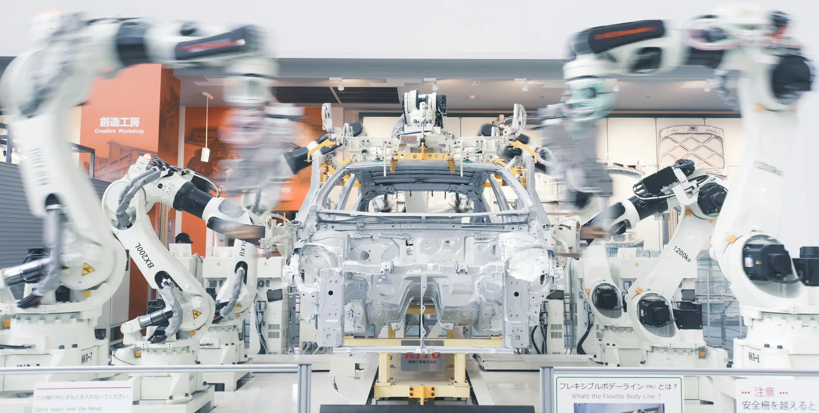 Robotic arms assembling a car body on a factory line