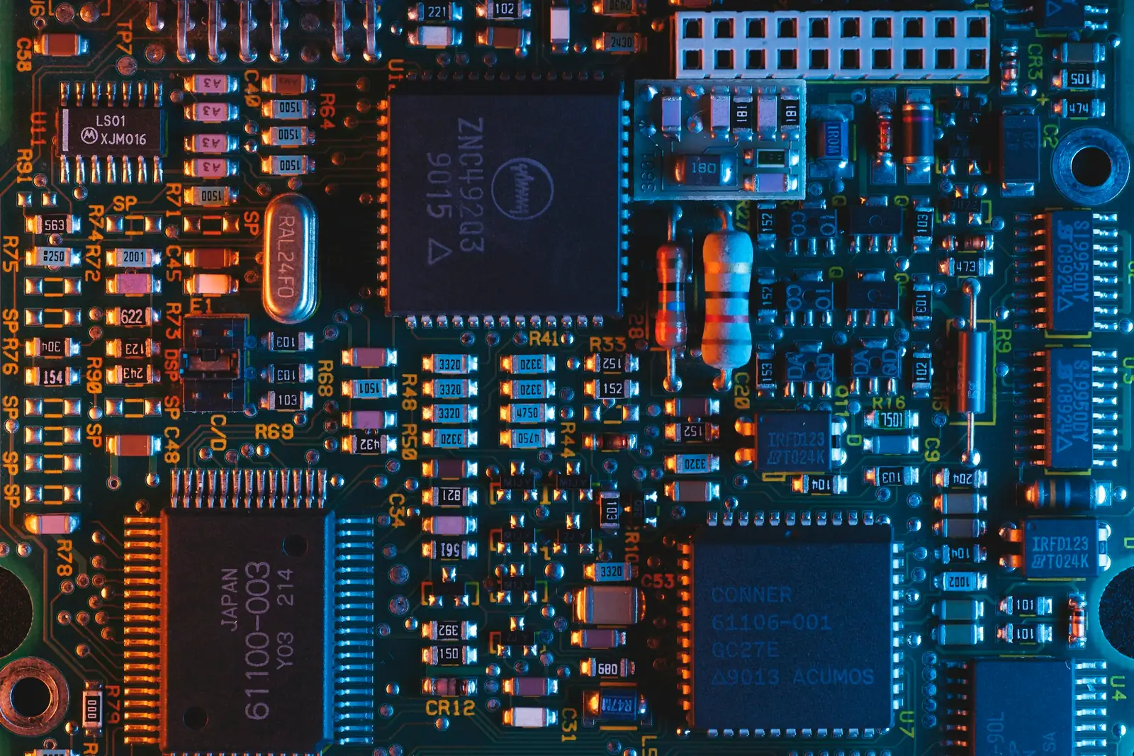 Close-up of a blue printed circuit board with chips and components